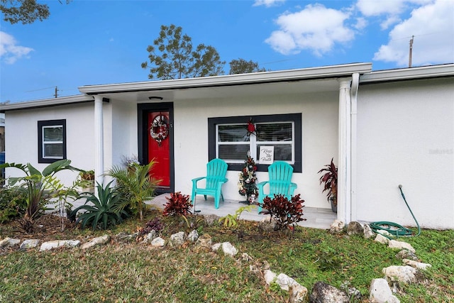 view of exterior entry featuring covered porch