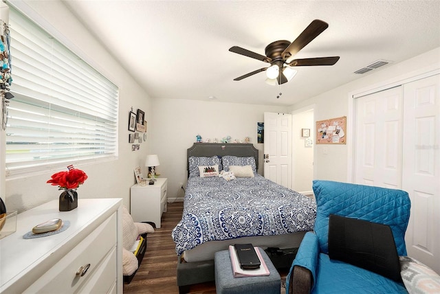 bedroom with dark hardwood / wood-style flooring, ceiling fan, and a closet