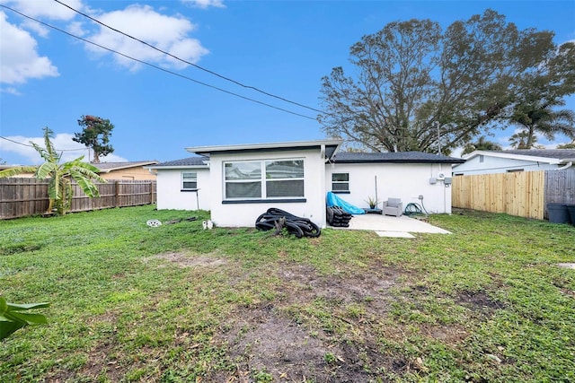 back of property with a patio and a lawn