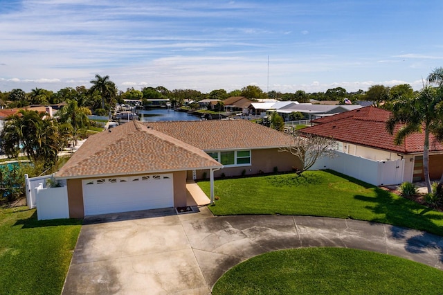 view of front facade with a garage, a front yard, and a water view