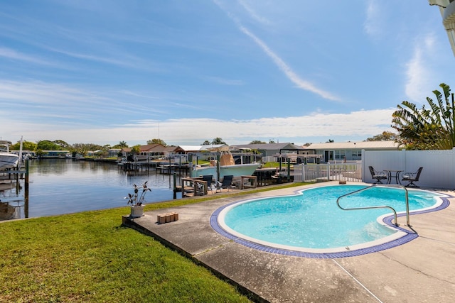 view of swimming pool featuring a water view, a dock, a patio area, and a lawn