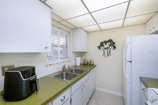 kitchen with sink, a drop ceiling, backsplash, white appliances, and white cabinets