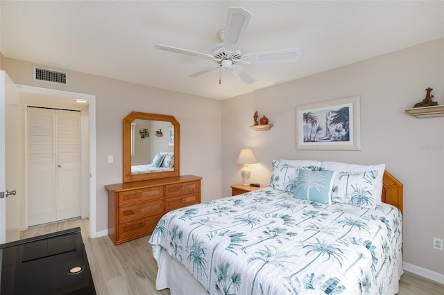 bedroom featuring ceiling fan, light hardwood / wood-style flooring, and a closet