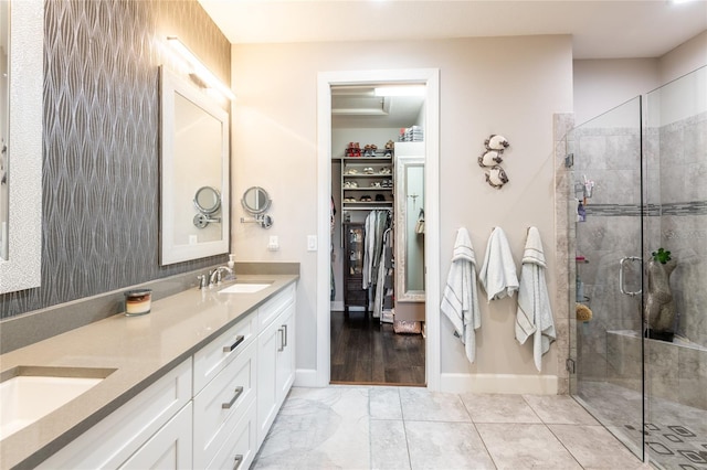 bathroom featuring a shower with door and vanity