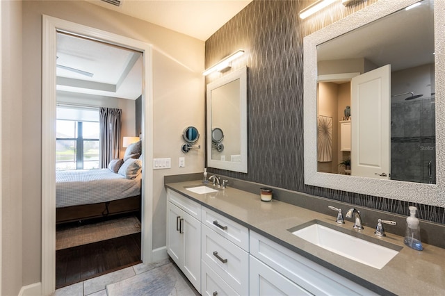 bathroom with tile patterned floors, vanity, and a shower