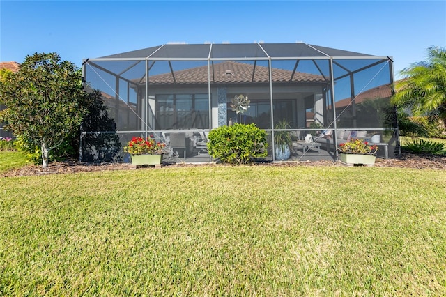 rear view of property featuring glass enclosure and a lawn