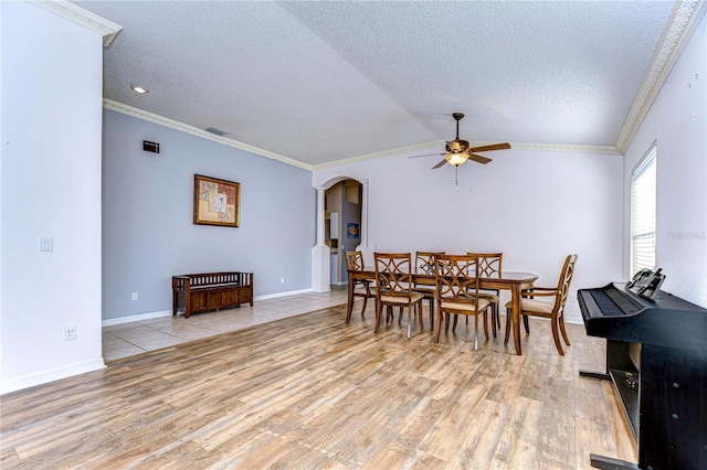 dining space featuring ceiling fan, ornamental molding, a textured ceiling, and light hardwood / wood-style flooring