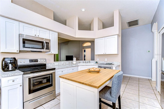 kitchen featuring kitchen peninsula, white cabinets, and appliances with stainless steel finishes