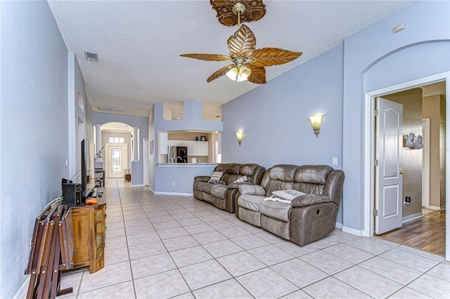 tiled living room featuring ceiling fan and a textured ceiling