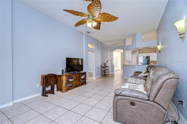 tiled living room with ceiling fan and a textured ceiling