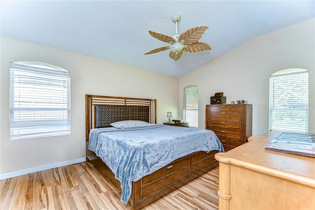 bedroom featuring ceiling fan, light hardwood / wood-style floors, and lofted ceiling