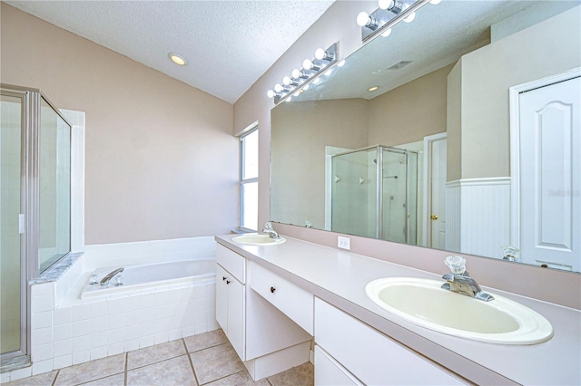 bathroom featuring tile patterned floors, vanity, a textured ceiling, and plus walk in shower