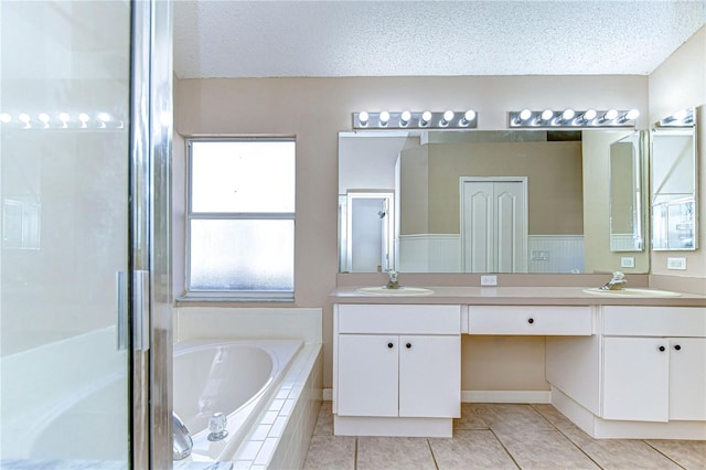 bathroom featuring tile patterned floors, vanity, independent shower and bath, and a textured ceiling