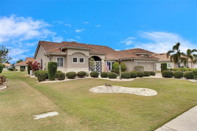 mediterranean / spanish home featuring a garage and a front lawn