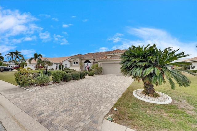 mediterranean / spanish house with a front yard and a garage