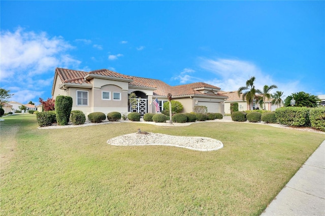 mediterranean / spanish-style home featuring a garage and a front lawn