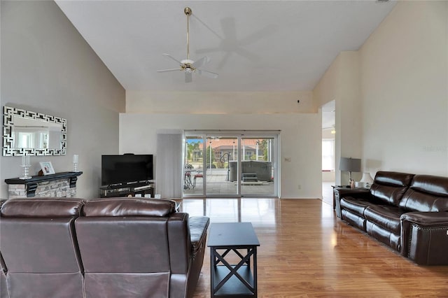 living room with ceiling fan, wood-type flooring, and lofted ceiling