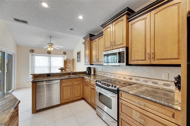 kitchen featuring stainless steel appliances, tasteful backsplash, kitchen peninsula, vaulted ceiling, and ceiling fan