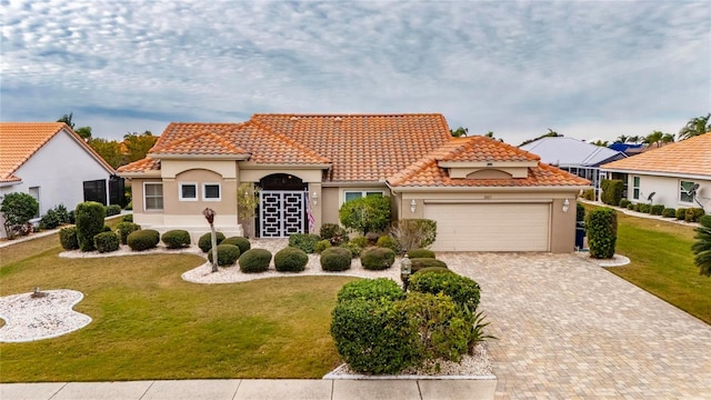 mediterranean / spanish home with a front yard and a garage