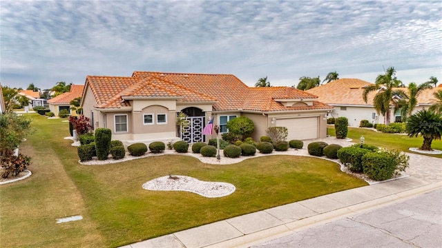 mediterranean / spanish house featuring a front yard and a garage