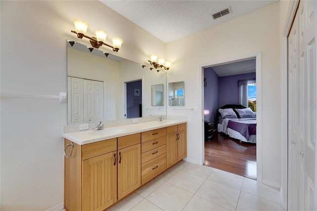 bathroom with vanity, tile patterned floors, and a textured ceiling