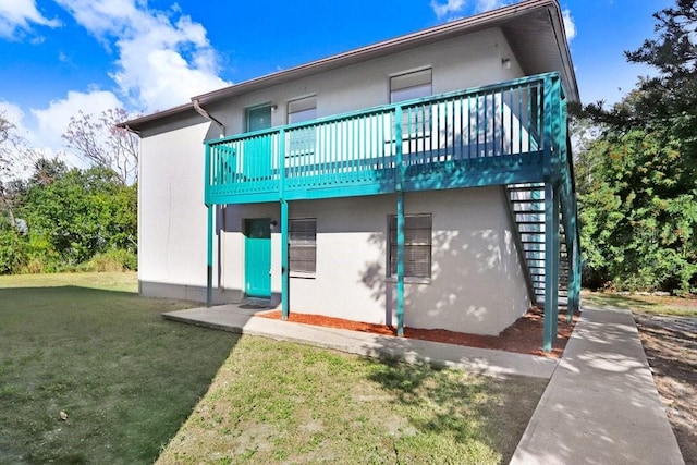 rear view of property with a lawn and a deck