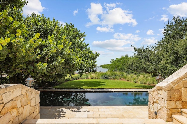 view of pool featuring a water view and a yard