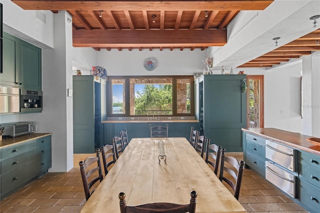 dining room featuring beamed ceiling and wooden ceiling