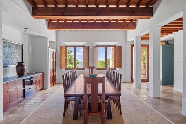 dining area featuring beam ceiling, a wealth of natural light, and wood ceiling