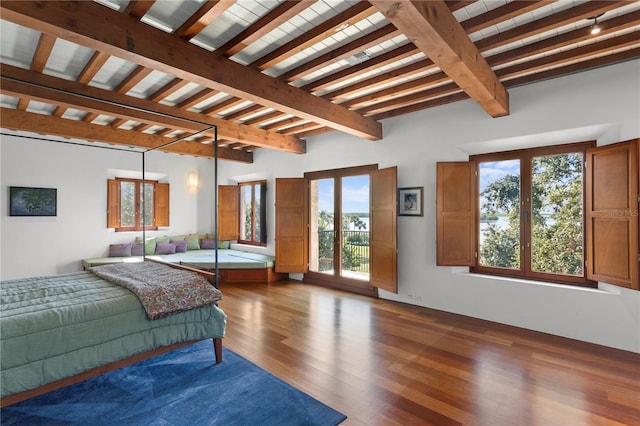 bedroom with beam ceiling and dark hardwood / wood-style flooring