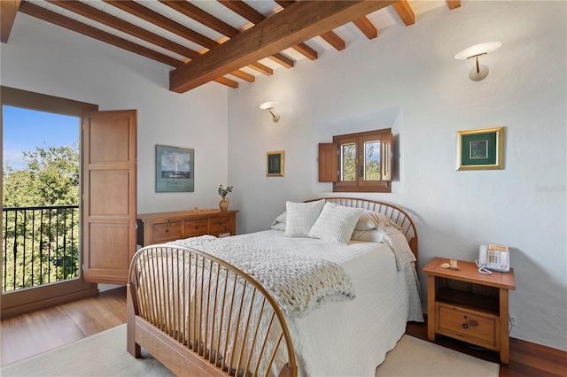 bedroom featuring vaulted ceiling with beams and light hardwood / wood-style floors