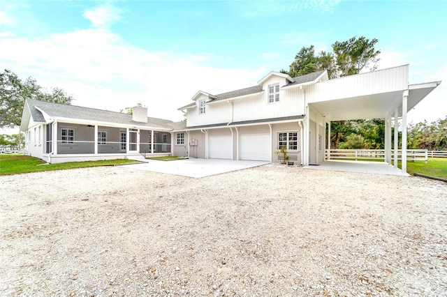 view of front facade featuring a garage and a sunroom