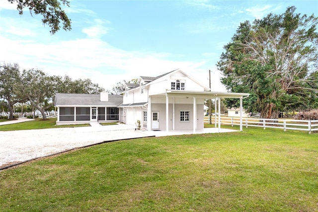 view of front of property featuring a sunroom and a front lawn