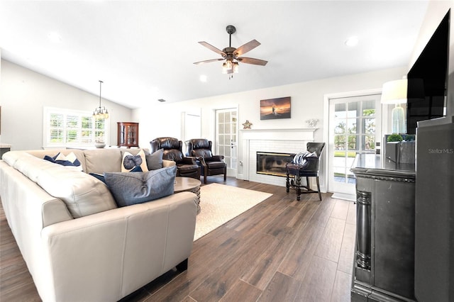 living room with vaulted ceiling, plenty of natural light, dark hardwood / wood-style floors, and a brick fireplace