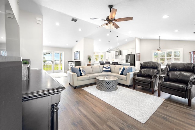 living room with dark wood-type flooring, ceiling fan, and high vaulted ceiling