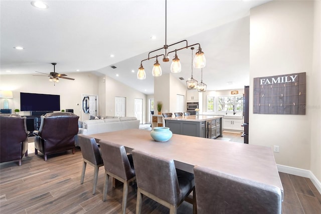 dining room featuring vaulted ceiling, dark wood-type flooring, and ceiling fan