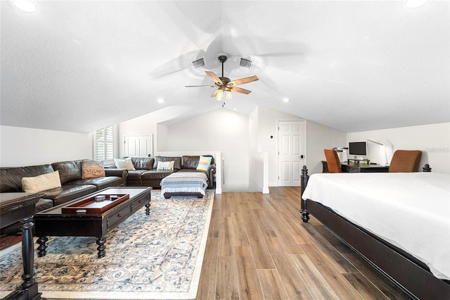 bedroom with lofted ceiling, ceiling fan, light hardwood / wood-style flooring, and a textured ceiling