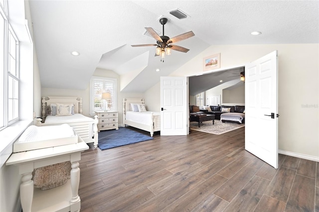 bedroom with dark wood-type flooring, vaulted ceiling, and a textured ceiling