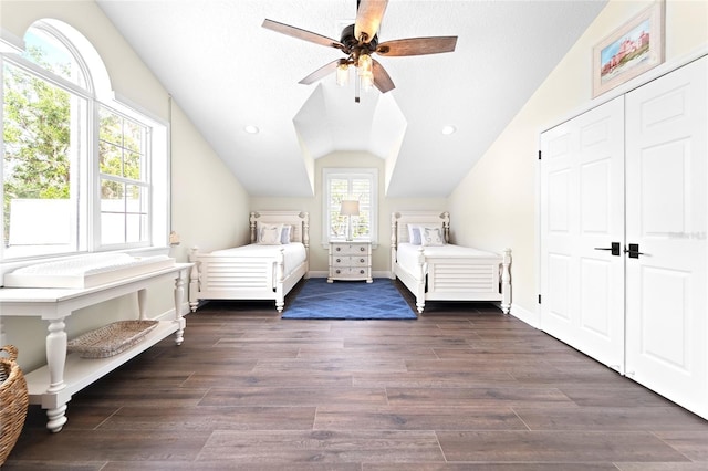 unfurnished bedroom with dark wood-type flooring, ceiling fan, lofted ceiling, and a textured ceiling