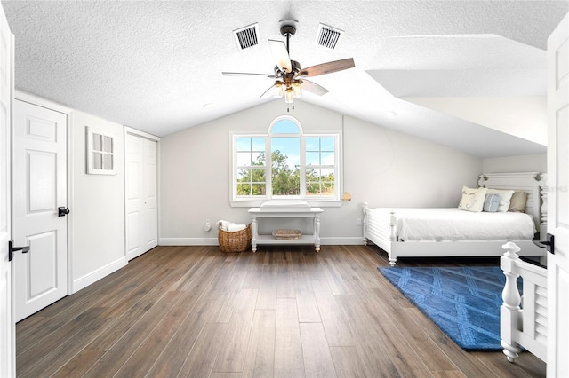 unfurnished bedroom with lofted ceiling, ceiling fan, dark wood-type flooring, and a textured ceiling