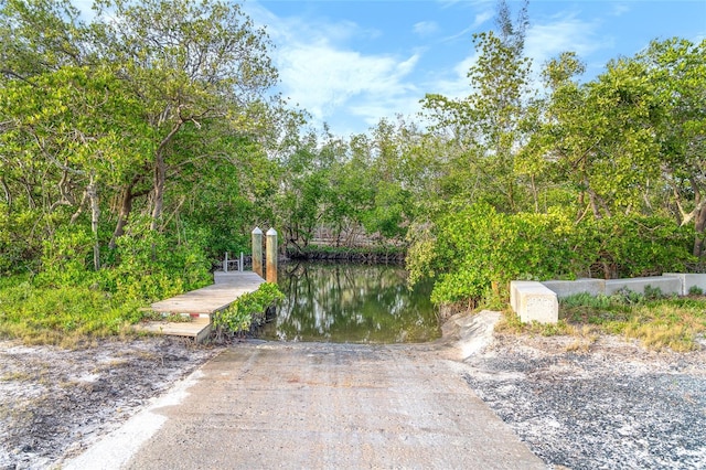 surrounding community featuring a dock and a water view