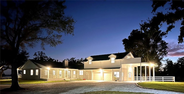 view of front of house with stucco siding, a lawn, driveway, and fence