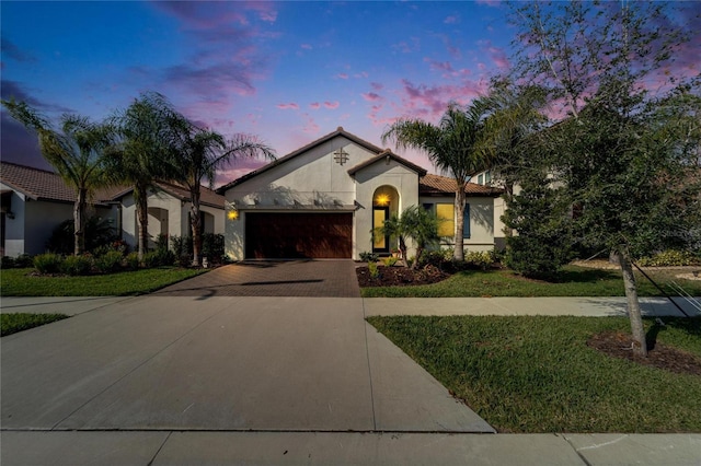 mediterranean / spanish house with a yard and a garage