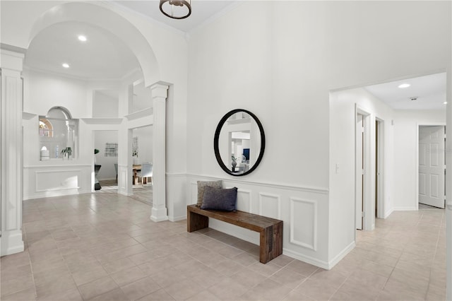 8701 Ballantrae Way, Tampa, FL 33647 - hallway featuring a towering ceiling, ornamental molding, decorative columns, and light tile patterned floors