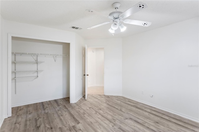 8701 Ballantrae Way, Tampa, FL 33647 - unfurnished bedroom featuring ceiling fan, a textured ceiling, light hardwood / wood-style floors, and a closet