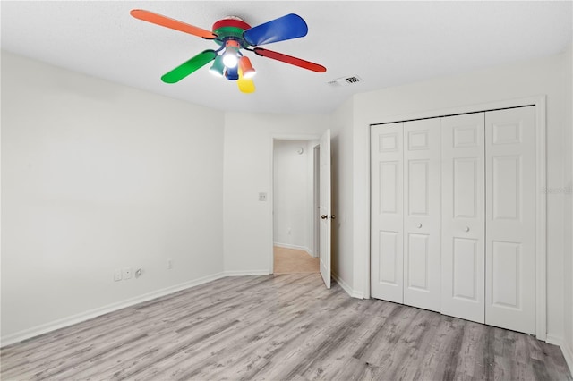 8701 Ballantrae Way, Tampa, FL 33647 - unfurnished bedroom featuring ceiling fan, light hardwood / wood-style floors, and a closet