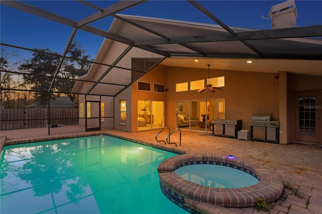 8701 Ballantrae Way, Tampa, FL 33647 - pool at dusk featuring a patio, a lanai, ceiling fan, and an in ground hot tub