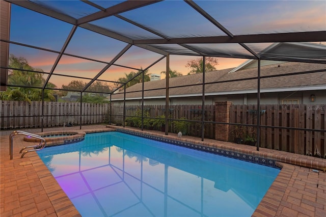 8701 Ballantrae Way, Tampa, FL 33647 - pool at dusk with an in ground hot tub, glass enclosure, and a patio