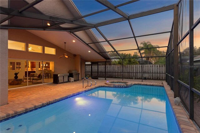 8701 Ballantrae Way, Tampa, FL 33647 - pool at dusk with an in ground hot tub, area for grilling, glass enclosure, and a patio area
