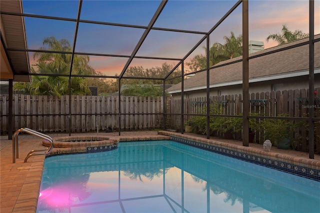8701 Ballantrae Way, Tampa, FL 33647 - pool at dusk featuring an in ground hot tub and glass enclosure